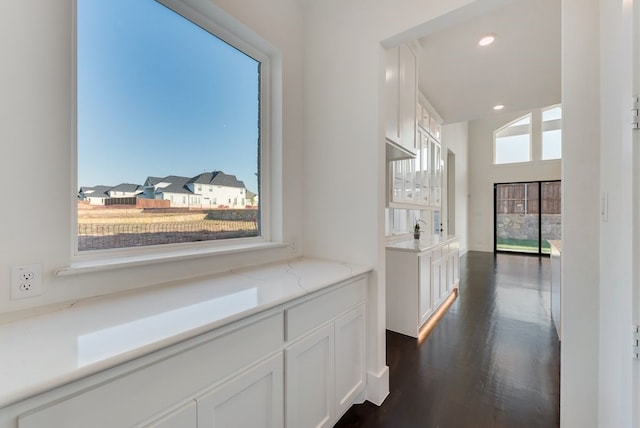 corridor featuring a residential view, dark wood finished floors, and recessed lighting