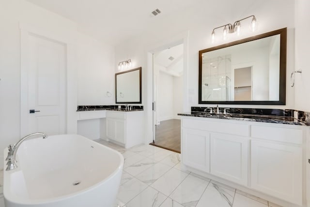 bathroom featuring marble finish floor, visible vents, a freestanding tub, and vanity