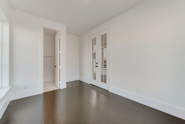 spare room featuring french doors, baseboards, and wood finished floors