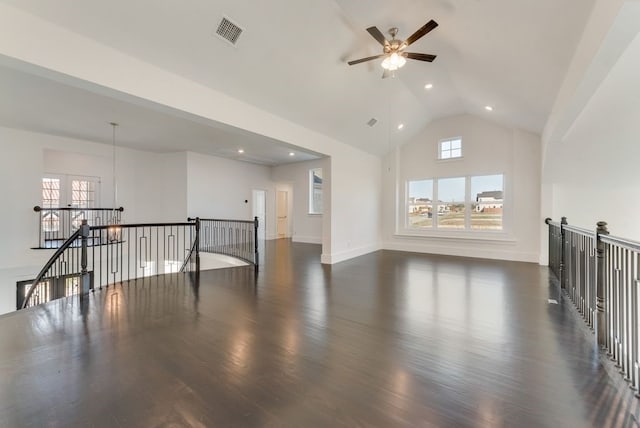 spare room featuring dark wood-type flooring, a wealth of natural light, visible vents, and high vaulted ceiling