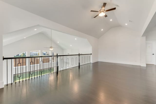 empty room with visible vents, a ceiling fan, wood finished floors, high vaulted ceiling, and baseboards