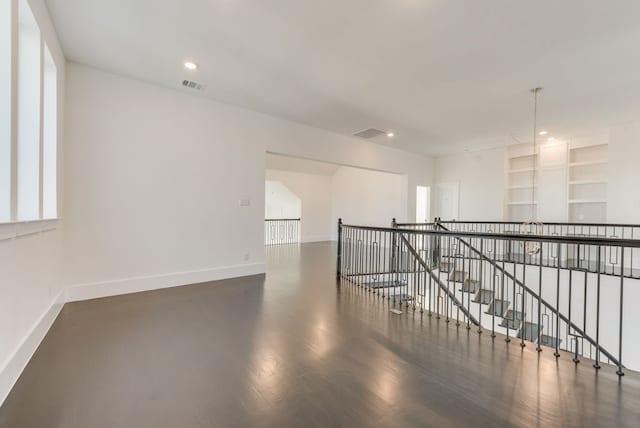 empty room with recessed lighting, built in features, visible vents, and baseboards