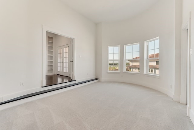 carpeted empty room with baseboards