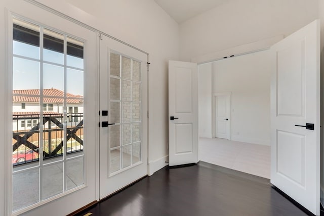 doorway with baseboards, dark wood-type flooring, and french doors