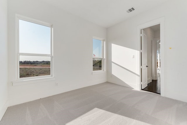 carpeted spare room featuring visible vents