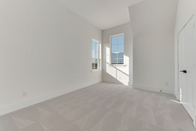 unfurnished room with light carpet and baseboards