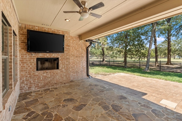 view of patio featuring ceiling fan and an outdoor brick fireplace