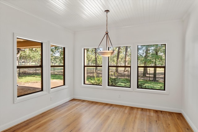 unfurnished dining area featuring ornamental molding and light wood-type flooring