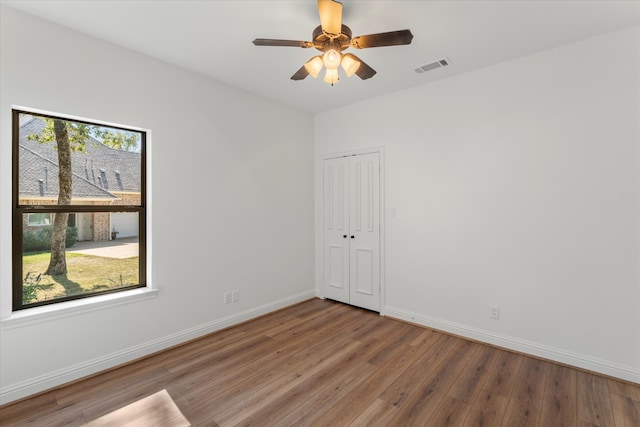 spare room featuring wood-type flooring, ceiling fan, and a wealth of natural light