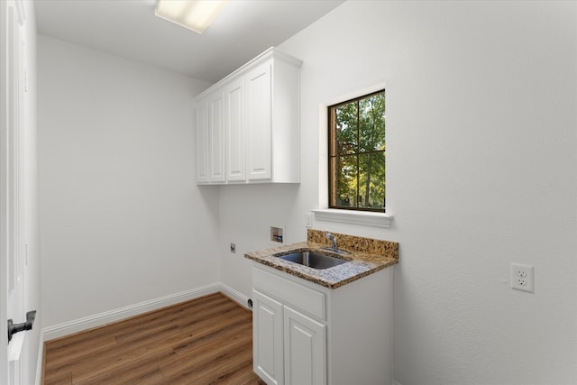 clothes washing area featuring sink, electric dryer hookup, hookup for a washing machine, cabinets, and hardwood / wood-style flooring