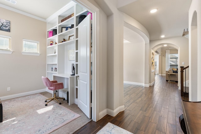 office with ornamental molding, built in desk, and dark hardwood / wood-style floors