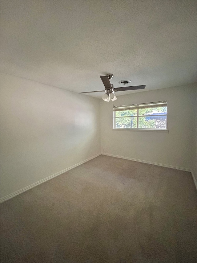 carpeted spare room featuring ceiling fan and a textured ceiling