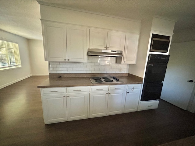 kitchen featuring white stovetop, decorative backsplash, dark hardwood / wood-style floors, white cabinets, and black oven