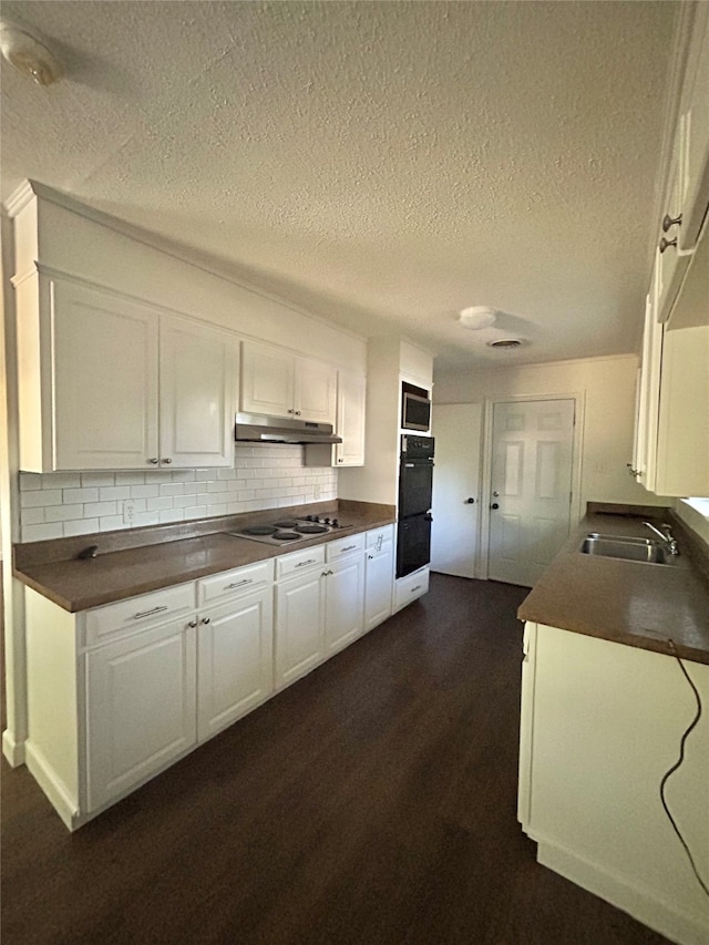 kitchen featuring white cabinets, double oven, sink, white gas stovetop, and dark hardwood / wood-style flooring