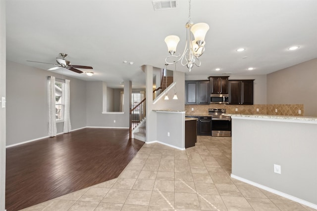 kitchen with light tile patterned floors, hanging light fixtures, appliances with stainless steel finishes, and dark brown cabinets