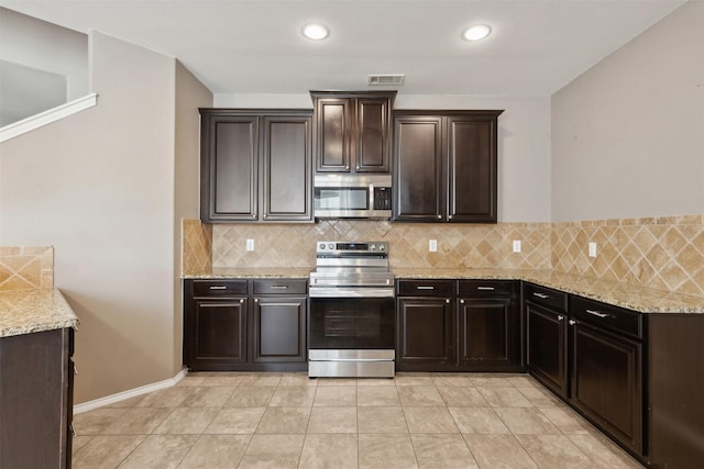 kitchen featuring light stone counters, appliances with stainless steel finishes, dark brown cabinets, and tasteful backsplash