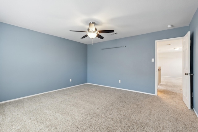 empty room featuring ceiling fan and light colored carpet