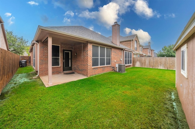 back of property featuring central air condition unit, a patio area, and a lawn