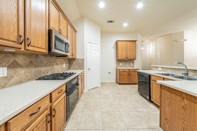 kitchen featuring sink, light stone counters, backsplash, light tile patterned floors, and black appliances