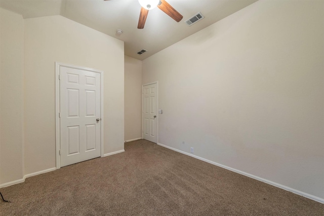 carpeted spare room with ceiling fan and vaulted ceiling