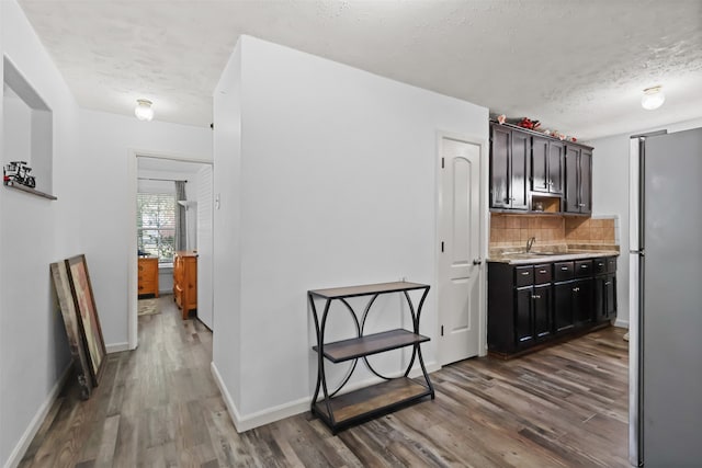 kitchen with stainless steel fridge, dark hardwood / wood-style floors, and a textured ceiling