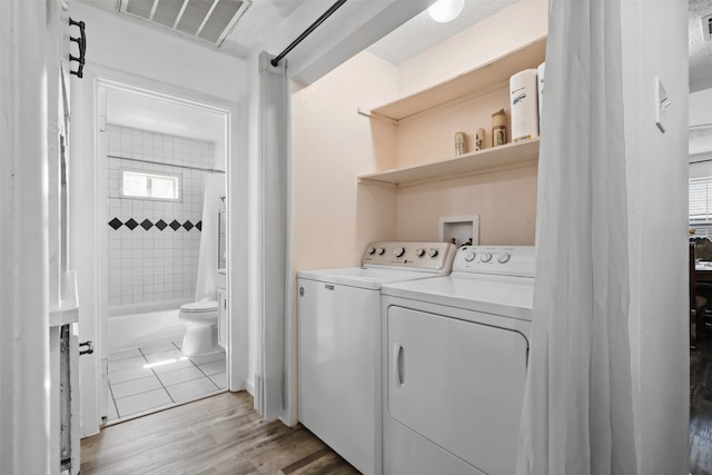 washroom with washer and clothes dryer and light hardwood / wood-style floors