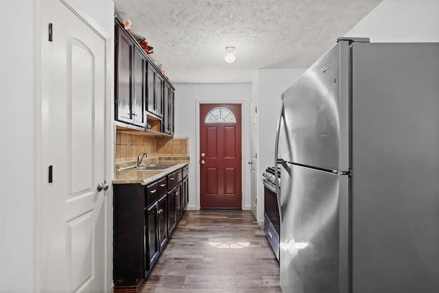 kitchen with tasteful backsplash, dark brown cabinetry, sink, stainless steel appliances, and dark hardwood / wood-style floors