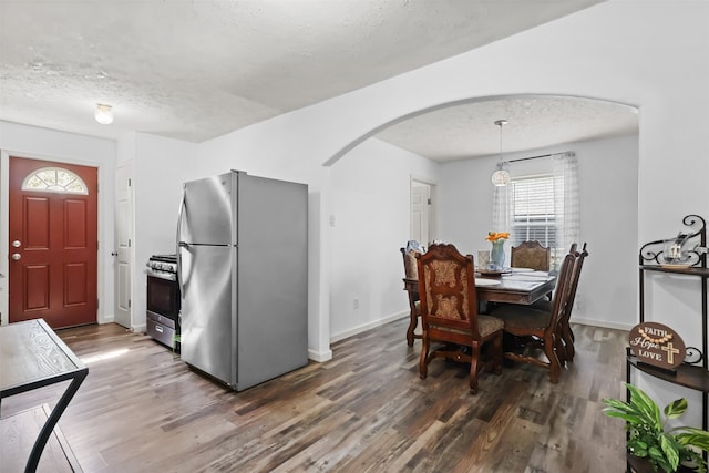 dining room featuring dark wood-type flooring and a textured ceiling