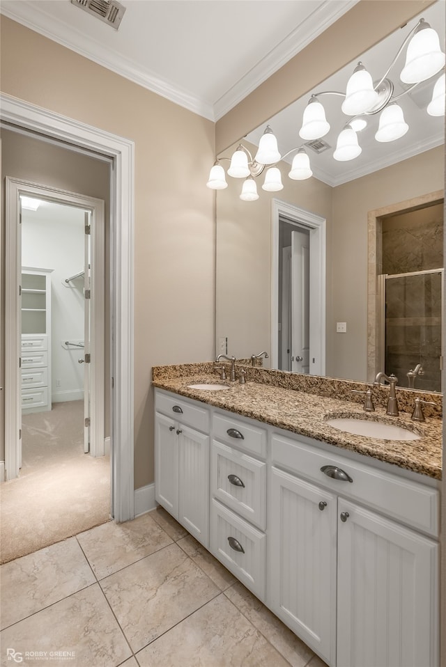 bathroom with vanity, a shower with door, and ornamental molding