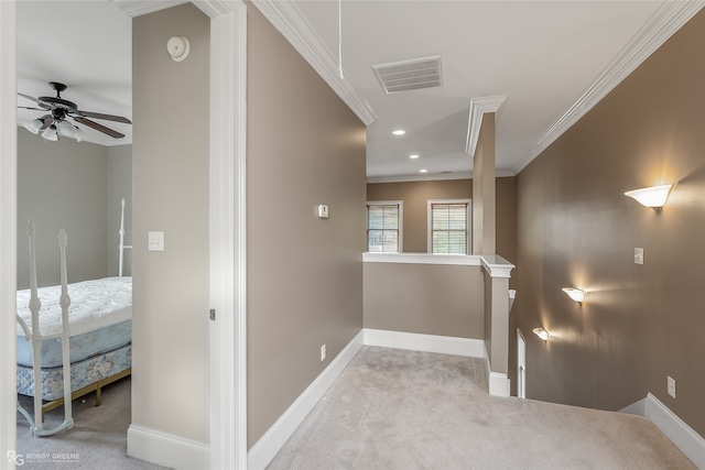 hall with crown molding and light carpet