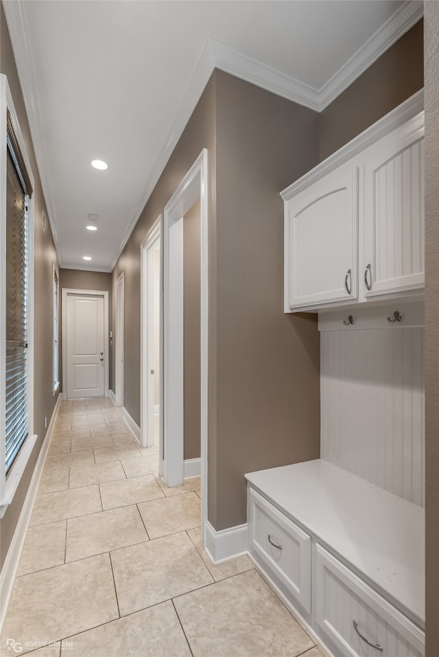 mudroom with light tile patterned floors and crown molding