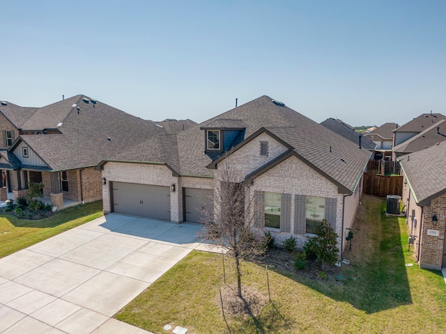 view of front of property featuring central air condition unit, a front yard, and a garage