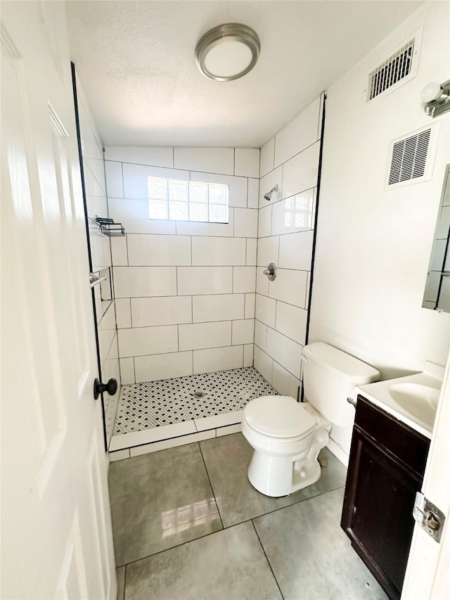 729 N Ruddell St, Denton, TX 76209 - bathroom with a tile shower, toilet, tile patterned floors, and vanity