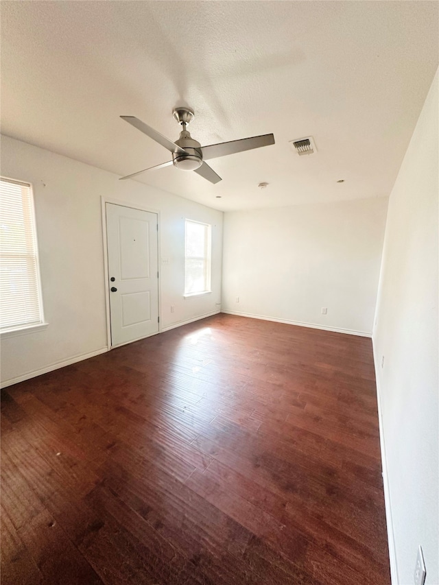 spare room with ceiling fan, dark hardwood / wood-style floors, and a textured ceiling