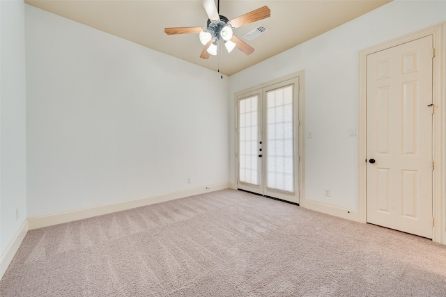 empty room with french doors, light colored carpet, and ceiling fan