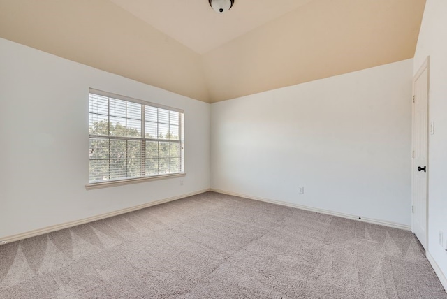 carpeted empty room with vaulted ceiling