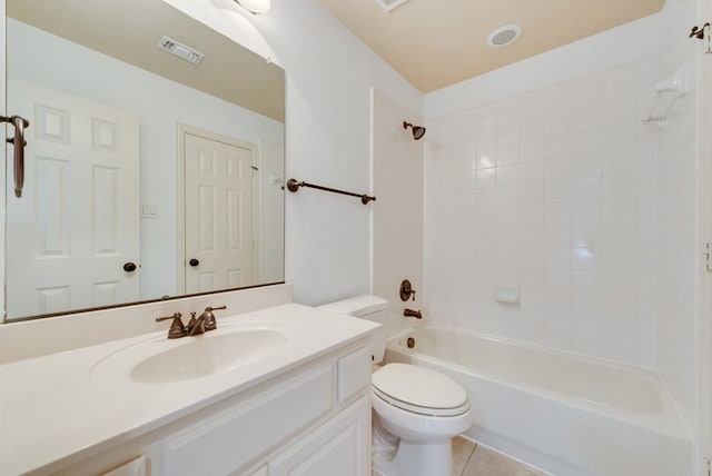 full bathroom with tiled shower / bath, tile patterned floors, vanity, and toilet