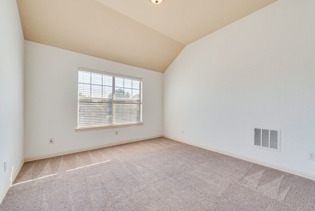 carpeted spare room featuring lofted ceiling