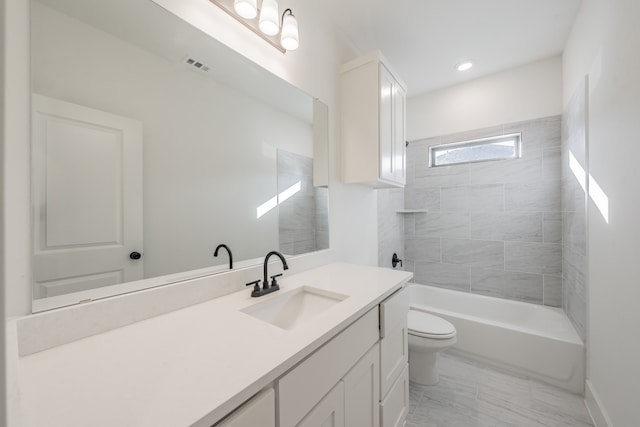 full bathroom with vanity, tiled shower / bath combo, and toilet