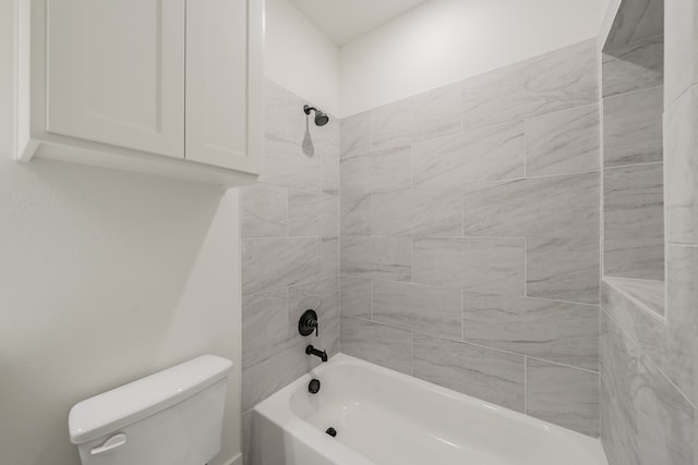 bathroom featuring tiled shower / bath combo and toilet