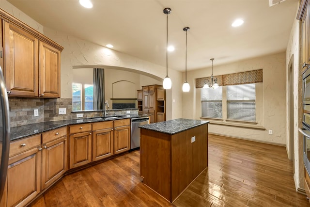 kitchen featuring appliances with stainless steel finishes, sink, dark wood-type flooring, and a center island