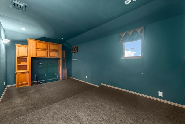 unfurnished living room featuring dark colored carpet and vaulted ceiling