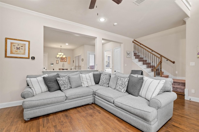 living room with ceiling fan with notable chandelier, crown molding, and hardwood / wood-style floors