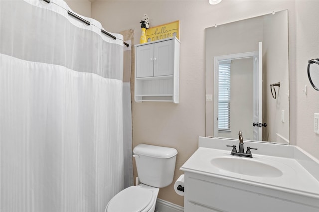 bathroom featuring vanity, curtained shower, and toilet