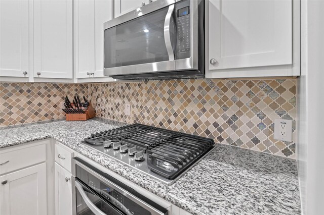 kitchen with white cabinets, hardwood / wood-style flooring, hanging light fixtures, and a chandelier