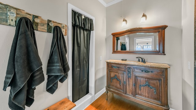 bathroom featuring hardwood / wood-style flooring, vanity, and crown molding