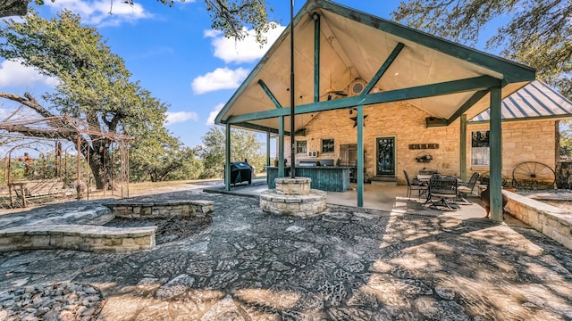 back of house featuring exterior bar and a patio