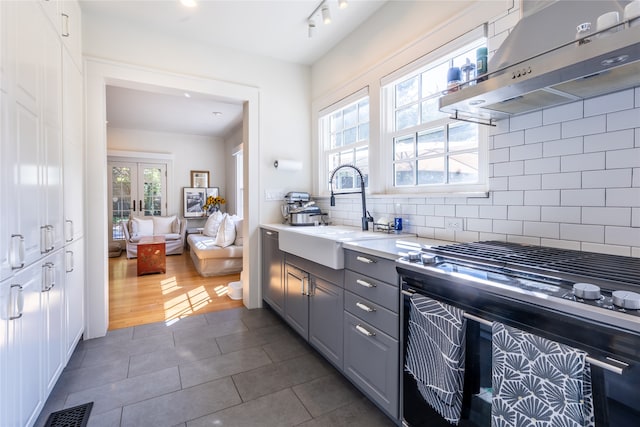 kitchen featuring extractor fan, a wealth of natural light, decorative backsplash, and gray cabinets