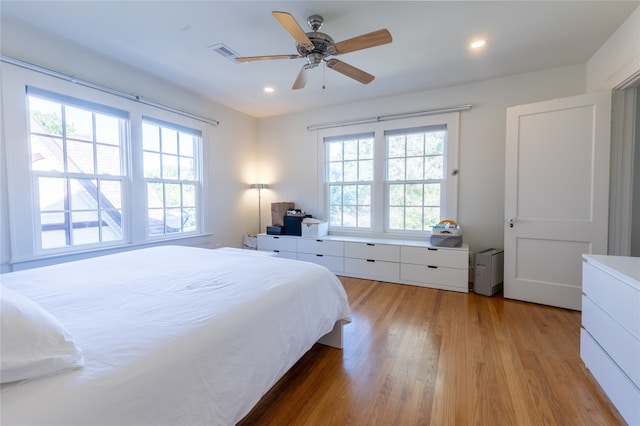 bedroom featuring light hardwood / wood-style flooring, multiple windows, and ceiling fan