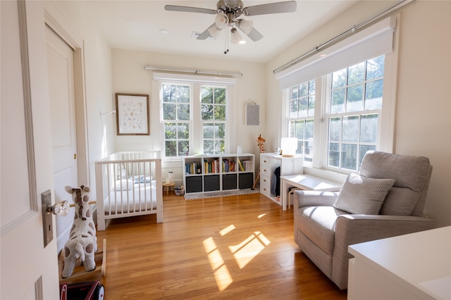 living area featuring wood-type flooring and ceiling fan